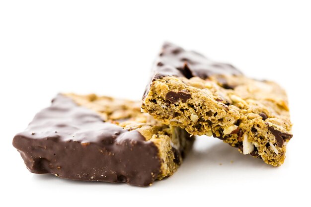 Vegan cowgirl squares dippen in chocolade op een witte achtergrond.