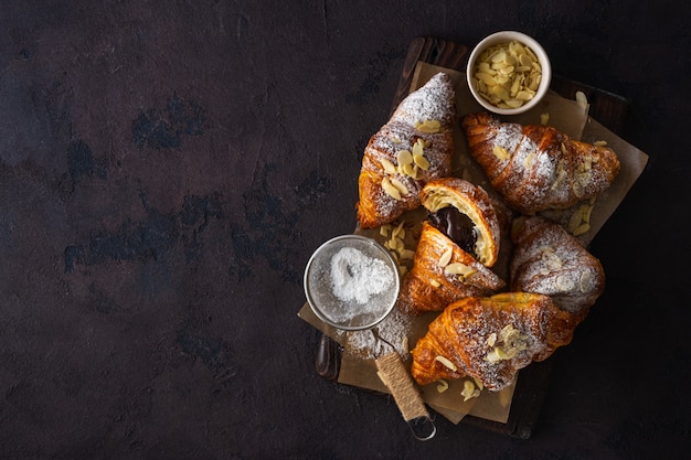 Vegan croissants with almond flakes and icing sugar top view copyspace