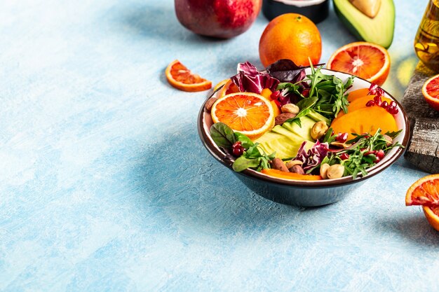 Vegan, detox Buddha bowl with fruit and vegetable, balanced food. on a blue background.