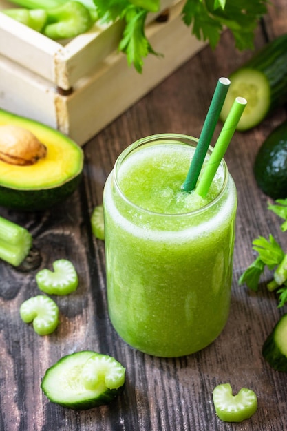 Vegan diet drinks Green smoothie celery avocado cucumber and spinach on a rustic table