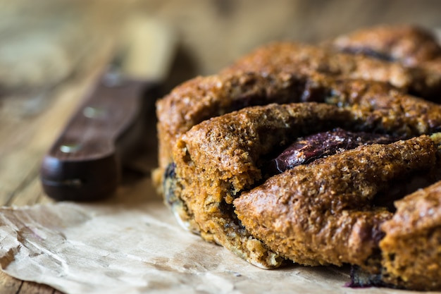 Photo vegan eggless whole wheat plum cake, knife, wood kitchen table, rustic kinfolk style