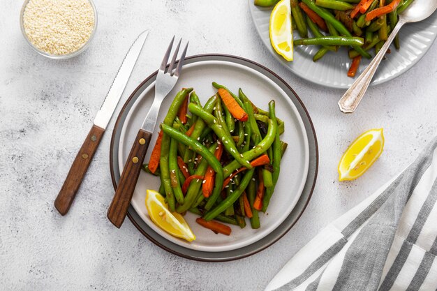 Vegan food. Cooked green string beans and carrots. Healthy salad of green beans and carrots close up.