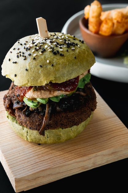 Vegan food, hamburger with spinach bread and fries.