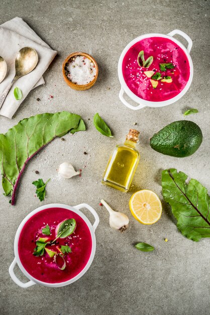 Vegan food, summer cold Beetroot gazpacho soup with lemon, avocado and fresh herbs