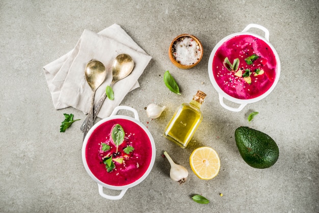 Vegan food, summer cold Beetroot gazpacho soup with lemon, avocado and fresh herbs