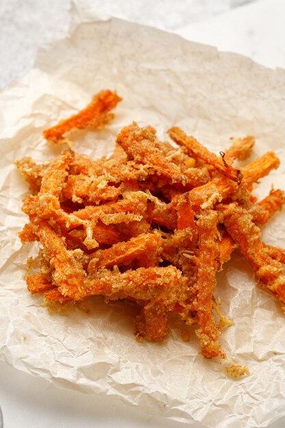 Vegan gebakken groente wortelstokjes Gezonde friet wortel op papier Voorgerecht of tussendoortje