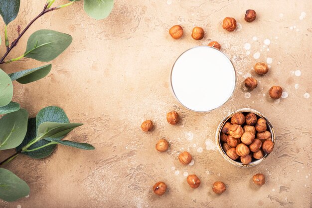 Vegan Hazelnut nut milk in bottles closeup beige table background Non dairy alternative milk Healthy vegetarian food and drink concept Copy space top view