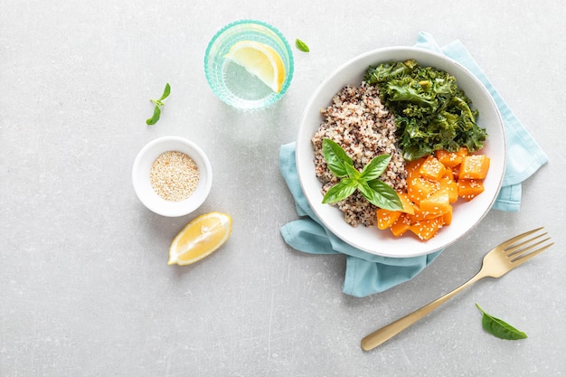 Vegan healthy lunch bowl with quinoa sauteed kale and baked butternut squash top down view