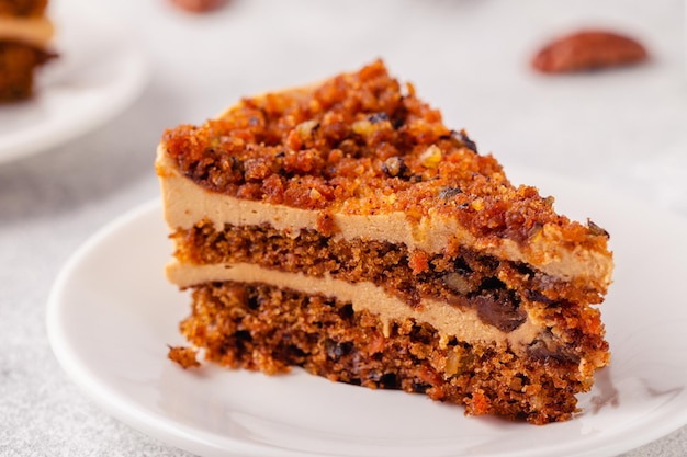 Vegan homemade carrot cake with pecans on a light background