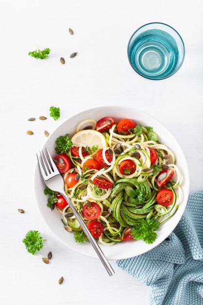 Vegan ketogenic spiralized courgette salad with avocado tomato pumpkin seeds