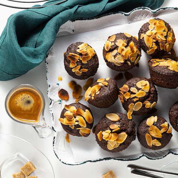 Vegan muffins met banaan en amandel chips met espresso op een dienblad glutenvrije en geraffineerde suikervrije paleo