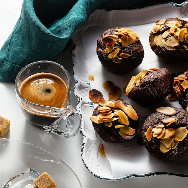 Vegan muffins with banana and almond chips with espresso on a tray gluten free and refined sugar free paleo