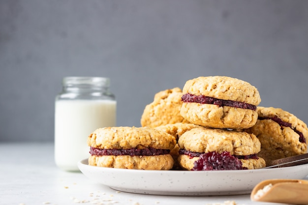 Vegan oat sandwich cookies with dried cranberry and orange. Healthy breakfast for children.