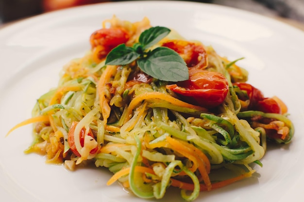 Vegan pasta a sliced vegetable salad zucchini tomatoes and carrots