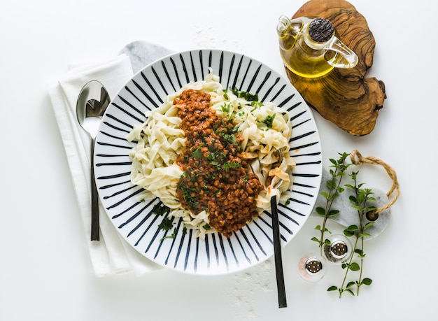 Vegan pasta with lentil and tomato sauce in a plate on the table