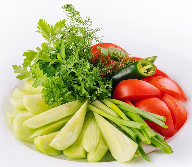 Vegan plate of fresh sliced cucumbers green onions and cherry tomatoes