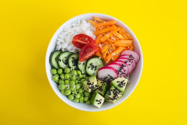 Vegan poke bowl with white rice and vegetables in bowl