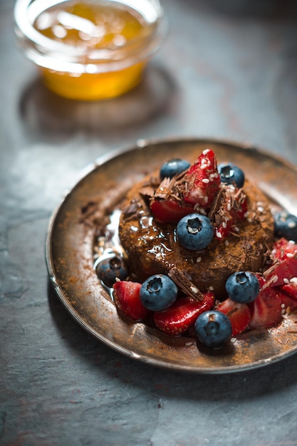 Vegan raw cake with bilberries and strawberries vertical