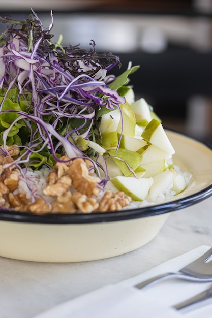 Vegan rice poke bowl with walnuts and green apple