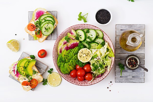 Vegan salad of fresh vegetables - tomatoes, cucumber, watermelon radish and avocado 