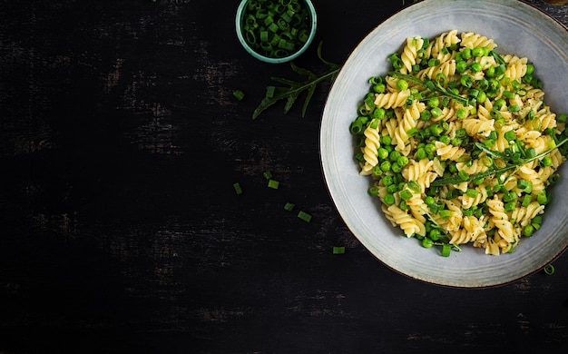 Insalata vegana. fusilli con piselli e cipolle. cibo italiano. vista dall'alto. lay piatto.