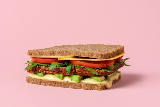 Vegan sandwich close-up geïsoleerd op een roze achtergrond