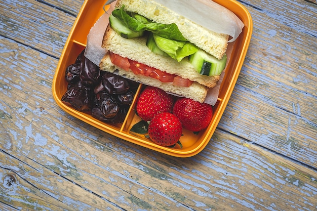 Foto vegan sandwich in plastic container op houten achtergrond