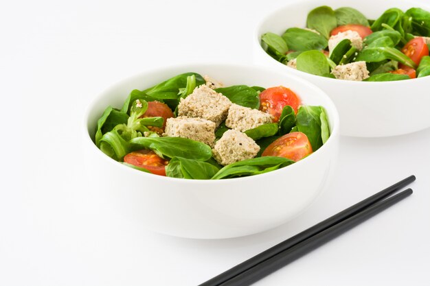 Vegan tofu salad with tomatoes and lamb's lettuce on white