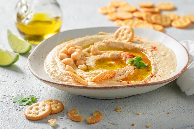 Vegan and traditional hummus with pumpkin seeds and crackers