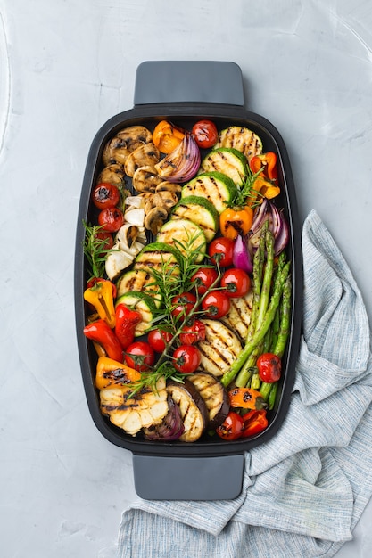 Vegan, vegetarian, seasonal, summer eating concept. Grilled vegetables in a pan on a table. Top view flat lay background