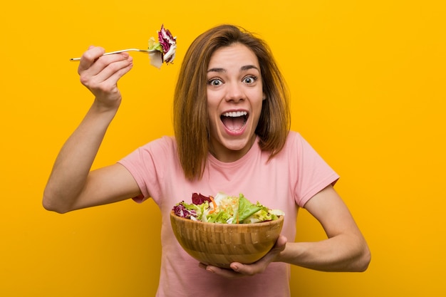 Veganist jonge vrouw die een verse en heerlijke salade eet.