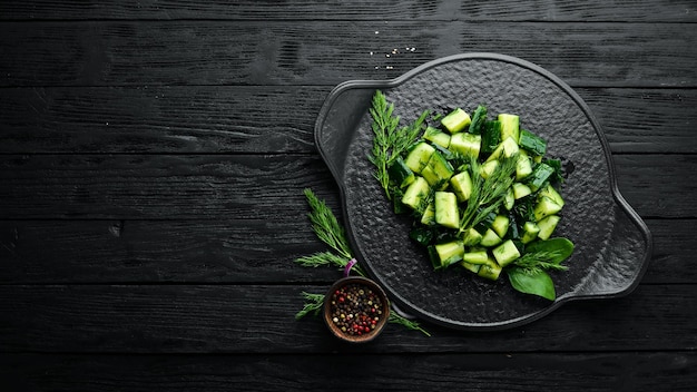 Veganistensalade met komkommer en dille op een zwarte plaat Rustieke stijl Bovenaanzicht Vrije ruimte voor uw tekst