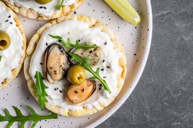 Veganistisch broodje met mosselen Knapperig brood zachte kaas en rucola salade Set smakelijke bruschetta voorgerecht Voedsel recept achtergrond Close-up bovenaanzicht