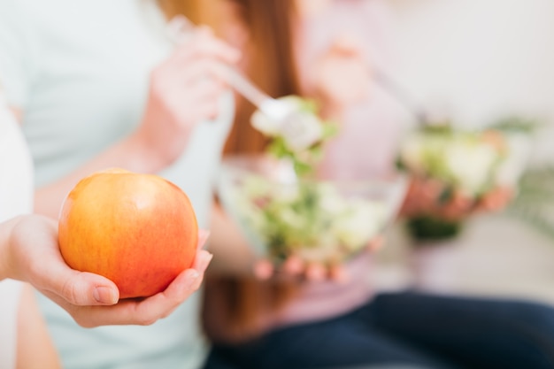 Veganistisch dieet. gezonde voeding levensstijl. appelvoorgerecht in vrouwelijke hand. vrouwen met saladekommen.