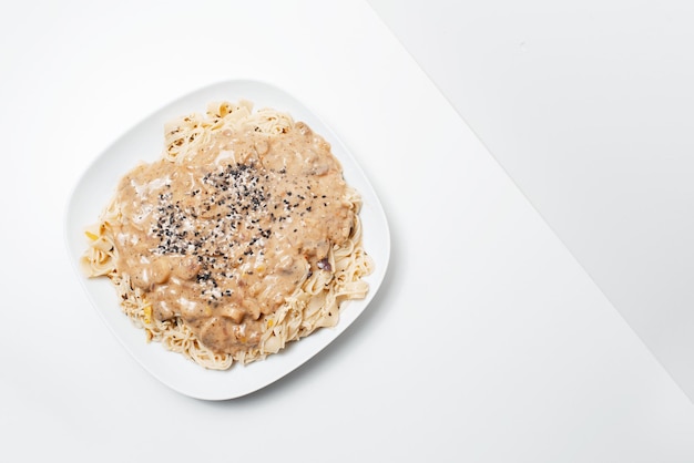 Veganistisch eten Bovenaanzicht van zelfgemaakte fettuccine pasta met Alfredo saus op wit