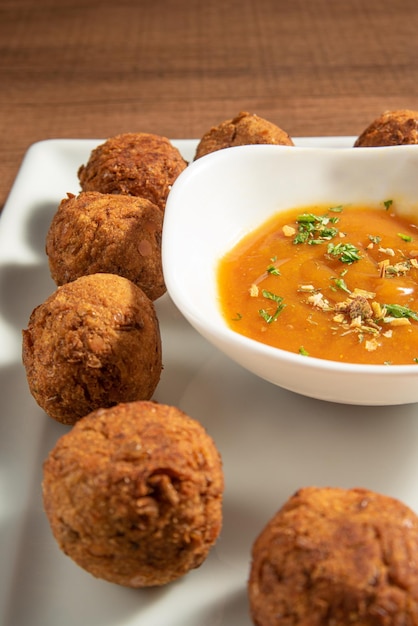 Veganistisch eten kikkererwten gehaktbal en saus op een witte plaat over hout selectieve focus