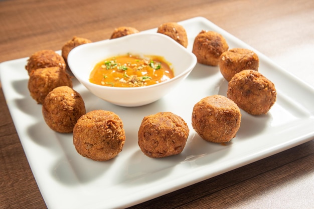 Veganistisch eten kikkererwten gehaktbal en saus op een witte plaat over hout selectieve focus