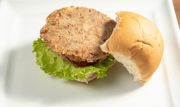 Veganistisch eten Veganistische hamburger en sauzen op een witte plaat over hout selectieve focus