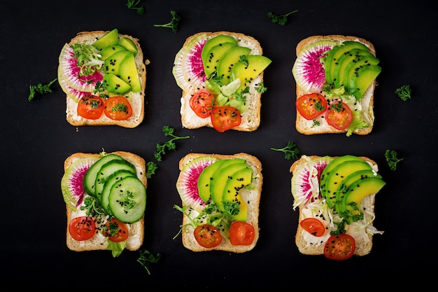 Veganistische broodjes met avocado, watermeloen radijs en tomaten