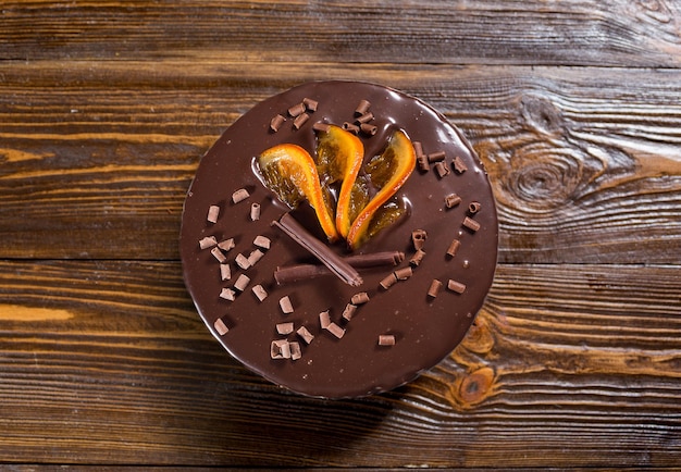 Veganistische donkere chocoladecake met gekonfijte sinaasappelen op houten achtergrond