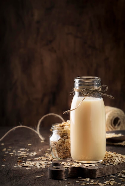 Veganistische havervlokken melk niet-zuivel alternatieve melk in glazen houten rustieke tafel kopieerruimte