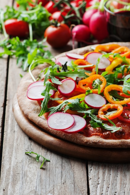 Veganistische pizza met radijs, tomaat en paprika