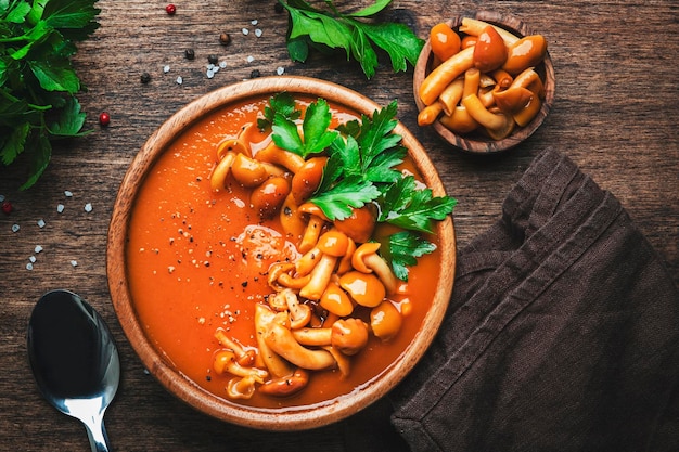 Veganistische romige pompoensoep met champignons hete peper en peterselie Winter of herfst gezond vegetarisch slowfood Houten kom op houten tafel achtergrond Bovenaanzicht