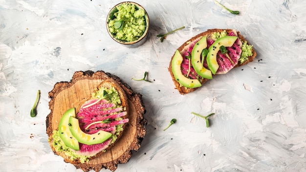 Veganistische sandwiches met avocado-watermeloenradijs en microgroen Heerlijk ontbijt of snack op een lichte achtergrond bovenaanzicht