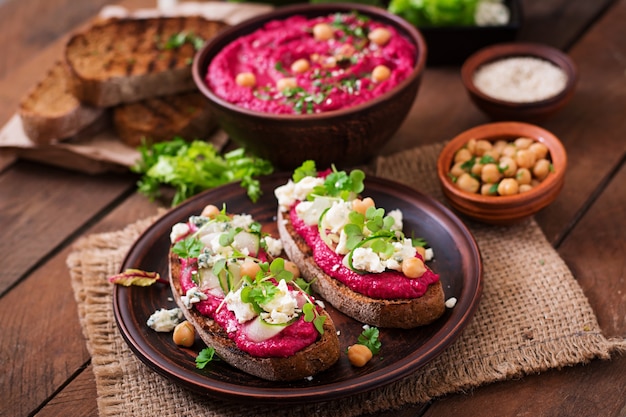 Veganistische sandwiches met hummus van rode biet, komkommer en blauwe kaas