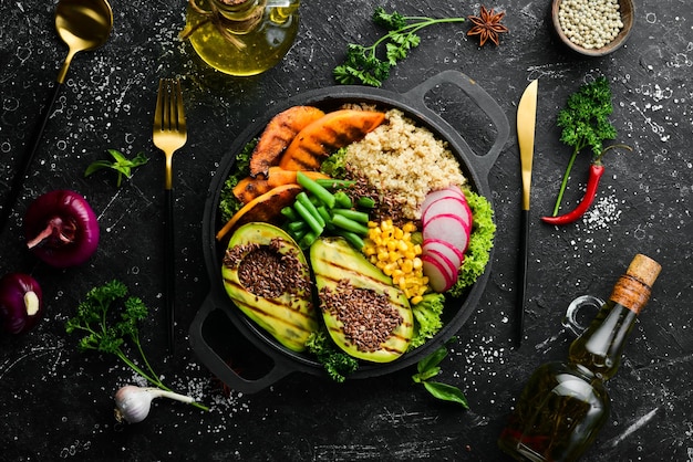 Veganistische schaal quinoa avocado pompoen met bonen en maïs in een zwarte schaal dieet Top view Vrije ruimte voor tekst