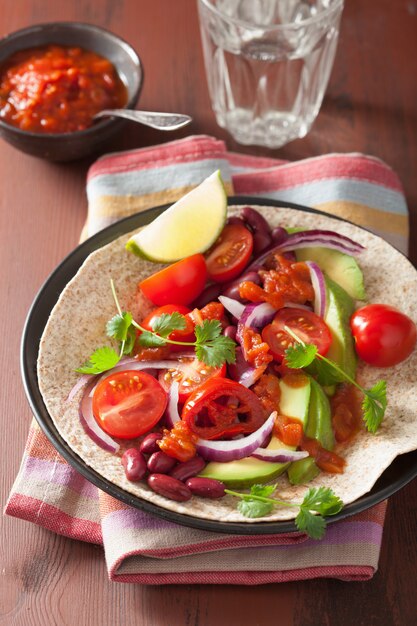 Veganistische taco met avocado-tomaten, bruine bonen en salsa