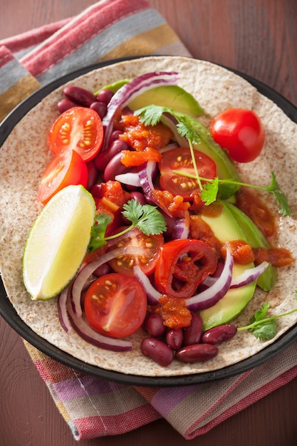 Veganistische taco met avocado-tomaten, bruine bonen en salsa