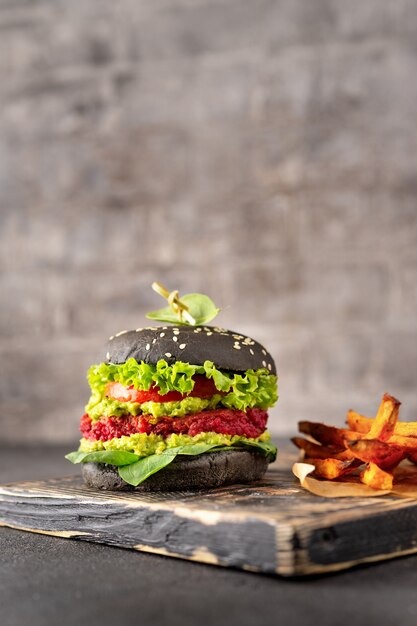 Veganistische zwarte burger met gebakken zoete aardappel