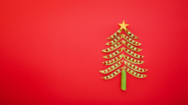 Vegans Christmas tree made of green peas on red background